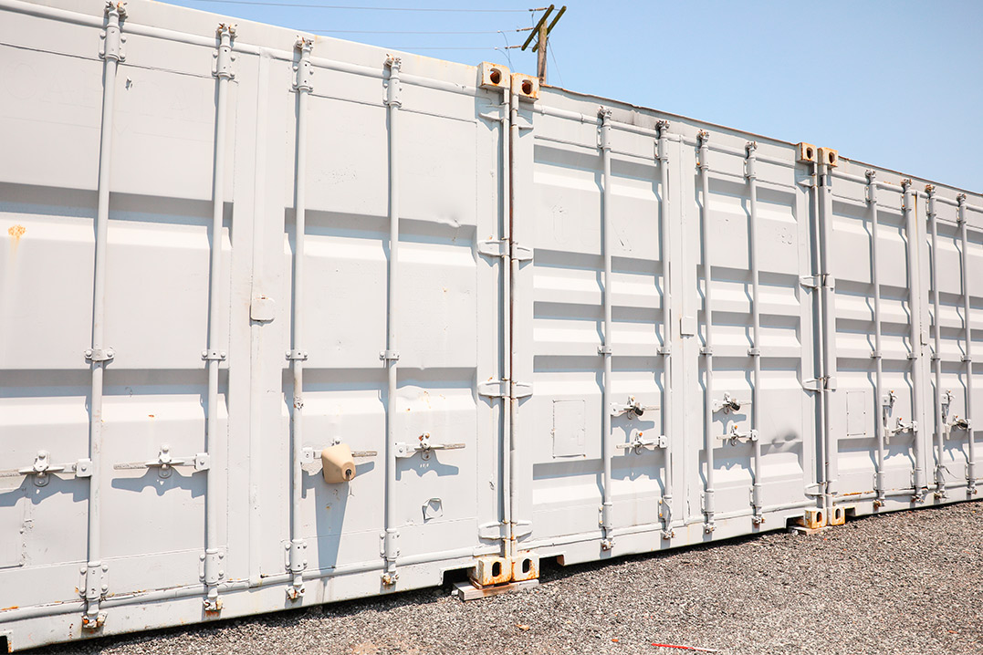 A 20-foot white shipping container placed on a gravel lot, ideal for small business needs.