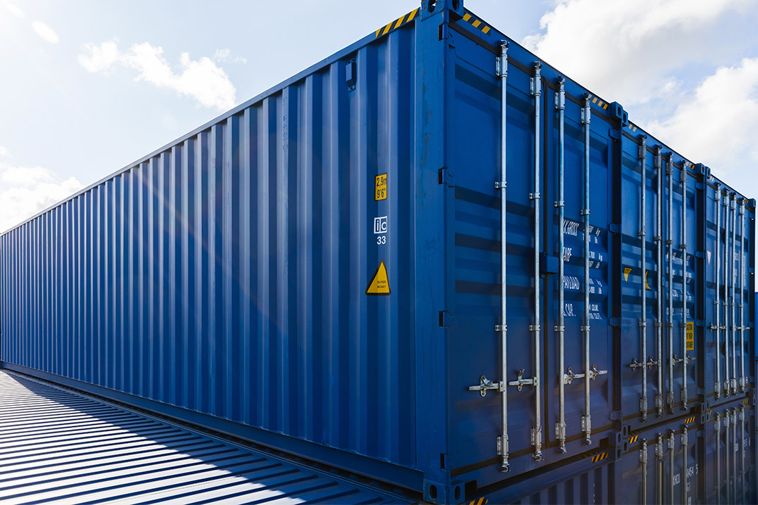 A blue shipping container atop a roof, illustrating its use as a secure and portable storage solution.