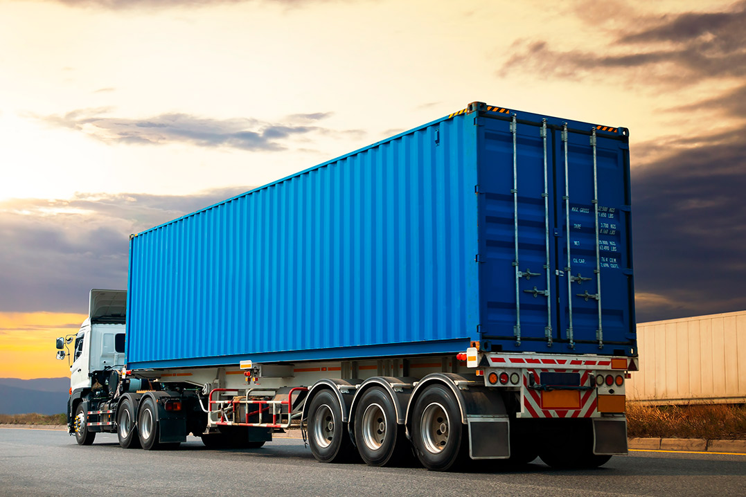 A blue container truck traveling down the road, emphasizing its role in transporting secure storage solutions.