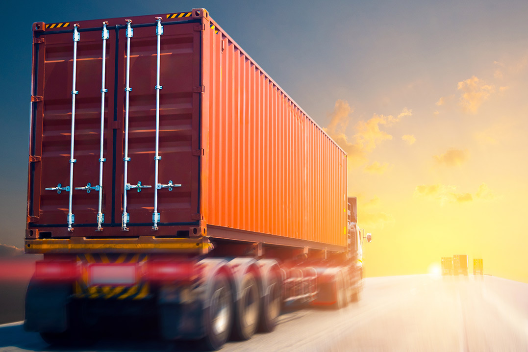 A truck transporting a container on the road, highlighting the role of 3PL bonded warehousing in cross-border logistics.