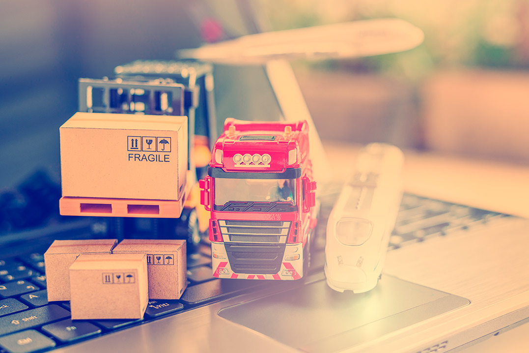 A laptop with a document on bonded warehouses, accompanied by a toy truck and assorted items on its surface.