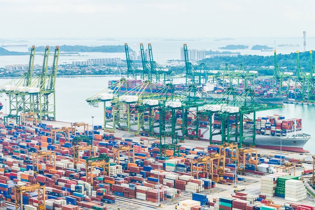 Overhead shot of a port showcasing numerous stacked containers, highlighting maritime trade and shipping activities.