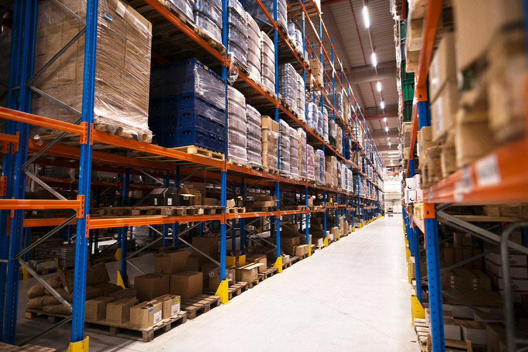 A spacious warehouse filled with numerous shelves stacked with boxes of various sizes.