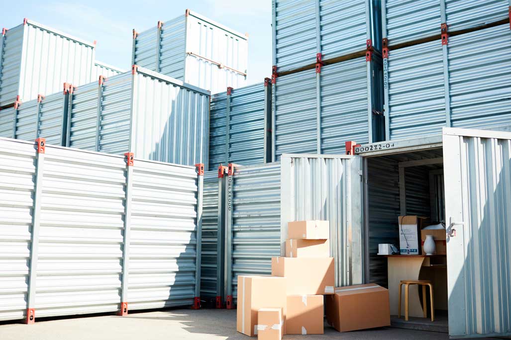 Open storage container with supplies for work and some packed boxes among other ones