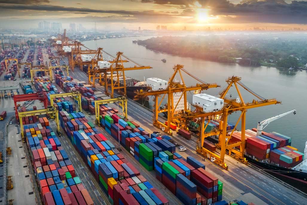 Logistics and transportation of Container Cargo ship and Cargo plane with working crane bridge in shipyard at sunrise, logistic import export and transport industry background