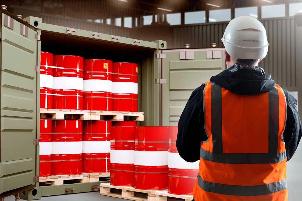 Logistics of chemical products. Man near container with barrels. Sea container with chemical products. Man is logistician in industrial building. Process of loading chemical substances into barrels