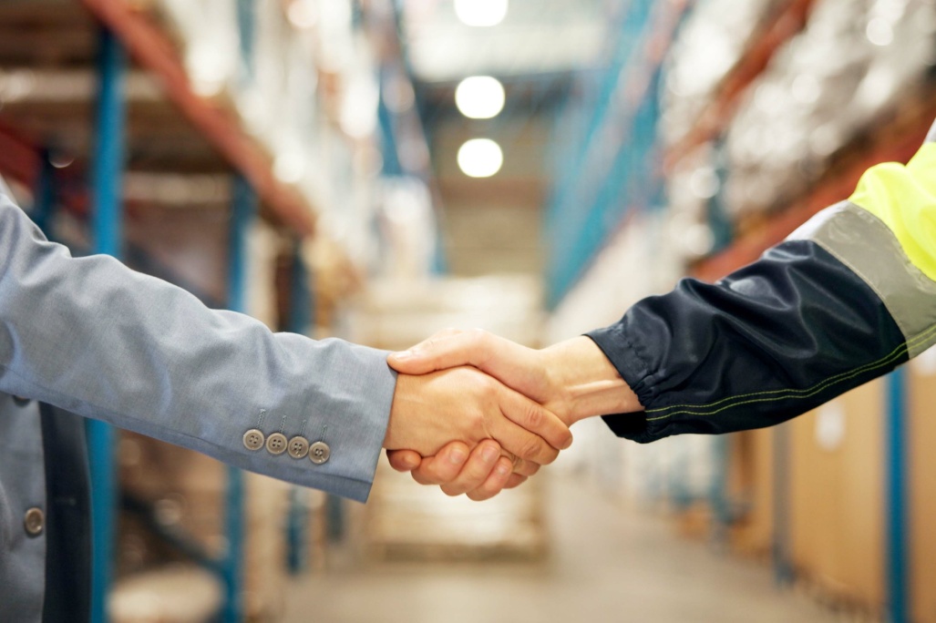 Business people, logistics or handshake with b2b in warehouse for partnership, deal or supply chain. Closeup, distributor or supplier shaking hands in aisle for shipping, distribution or wholesale