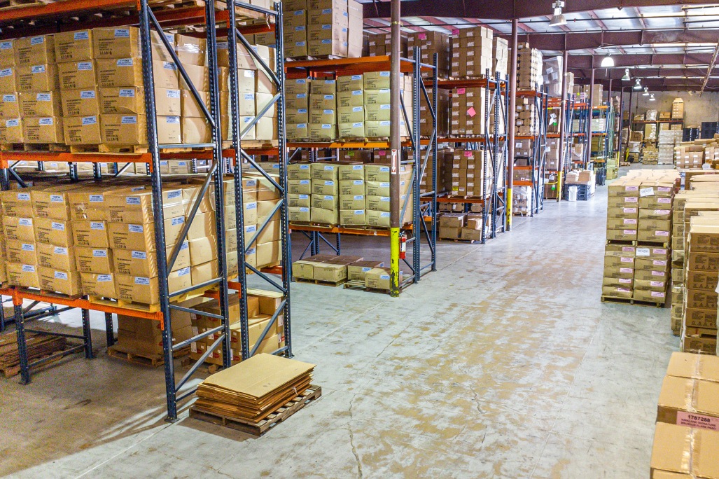 Interior view of a warehouse showcasing numerous boxes and pallets, representing 3PL bonded storage solutions.